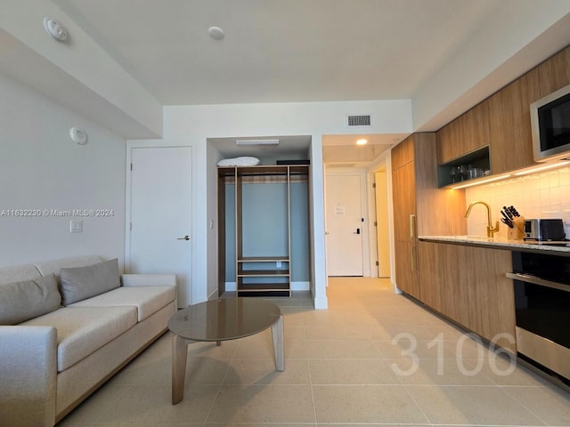 living area with light tile patterned floors and visible vents