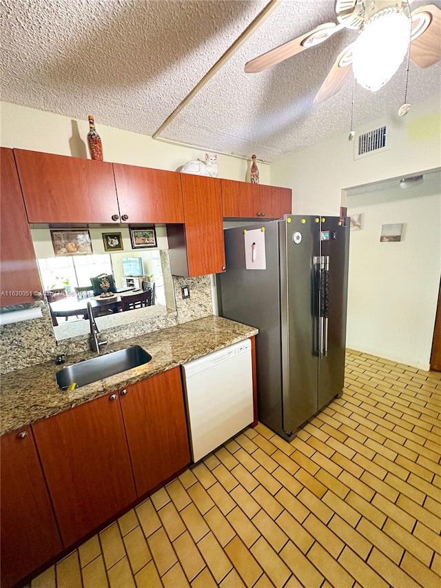 kitchen with tasteful backsplash, a textured ceiling, white dishwasher, ceiling fan, and sink