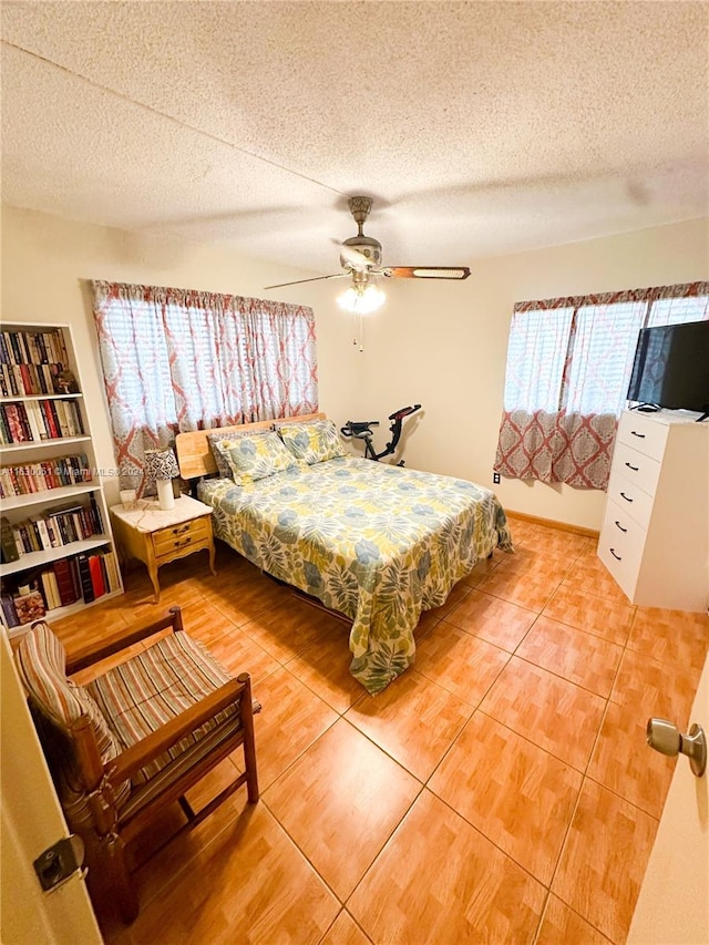 tiled bedroom featuring a textured ceiling and ceiling fan