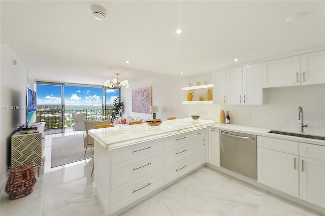 kitchen featuring white cabinetry, stainless steel dishwasher, an inviting chandelier, sink, and kitchen peninsula