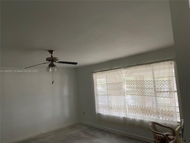 spare room with ceiling fan and concrete flooring