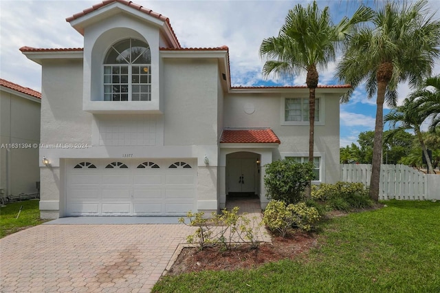 13377 NW 7th St, Plantation, FL 33325 - mediterranean / spanish house with a tiled roof, decorative driveway, fence, an attached garage, and stucco siding
