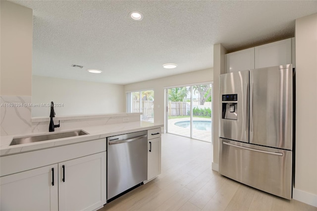 13377 NW 7th St, Plantation, FL 33325 - kitchen featuring a sink, white cabinets, stainless steel appliances, and a textured ceiling