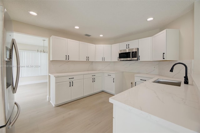 13377 NW 7th St, Plantation, FL 33325 - kitchen with decorative backsplash, light stone countertops, a sink, light wood-style floors, and stainless steel appliances