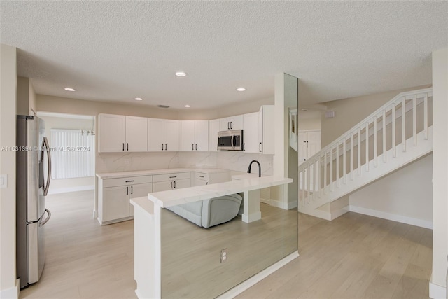 13377 NW 7th St, Plantation, FL 33325 - kitchen with backsplash, stainless steel appliances, light wood-type flooring, and white cabinetry