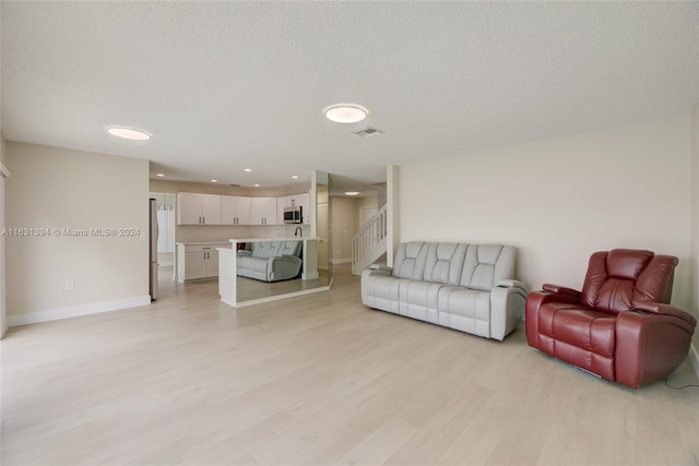 13377 NW 7th St, Plantation, FL 33325 - living area featuring a textured ceiling, recessed lighting, baseboards, light wood-type flooring, and stairway