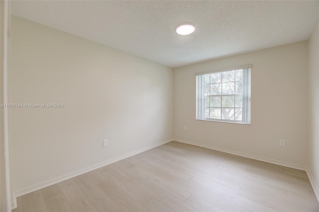 13377 NW 7th St, Plantation, FL 33325 - empty room with baseboards, a textured ceiling, and light wood finished floors