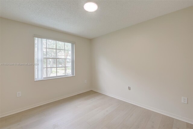 13377 NW 7th St, Plantation, FL 33325 - empty room featuring light wood-style floors, a textured ceiling, and baseboards