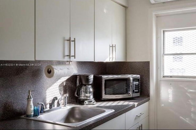 kitchen with sink, white cabinetry, and tasteful backsplash