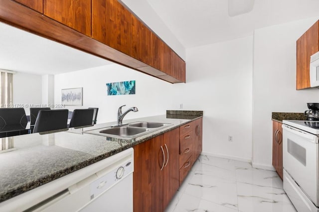 kitchen with light tile patterned flooring, sink, dark stone counters, and white appliances