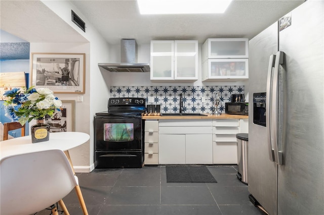 kitchen featuring sink, wall chimney exhaust hood, decorative backsplash, white cabinets, and black appliances