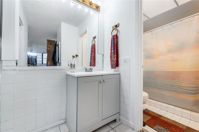 bathroom featuring tile patterned flooring, vanity, a shower with shower curtain, and toilet