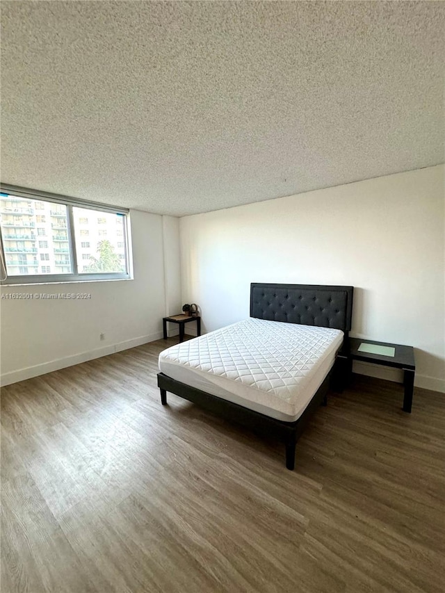 bedroom featuring a textured ceiling and hardwood / wood-style floors