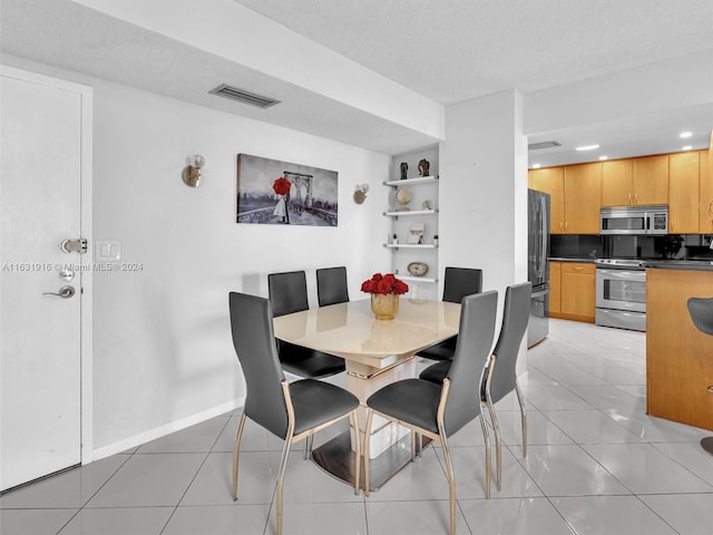 tiled dining space with a textured ceiling