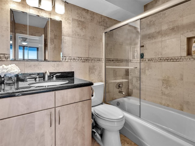 full bathroom featuring enclosed tub / shower combo, tile walls, tile patterned flooring, toilet, and vanity