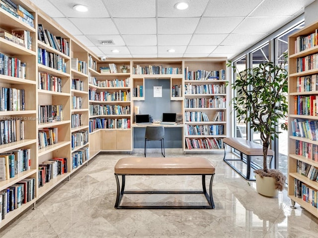 sitting room featuring light tile patterned flooring, a drop ceiling, and plenty of natural light