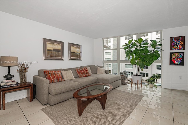 living room with light tile patterned floors and a wall of windows