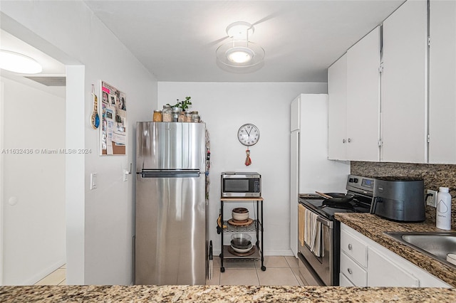 kitchen featuring white cabinetry, stainless steel appliances, sink, and light tile patterned floors