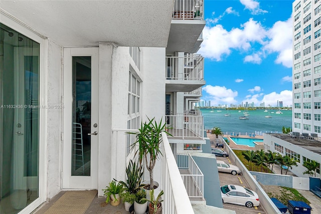 balcony with a water view and a community pool