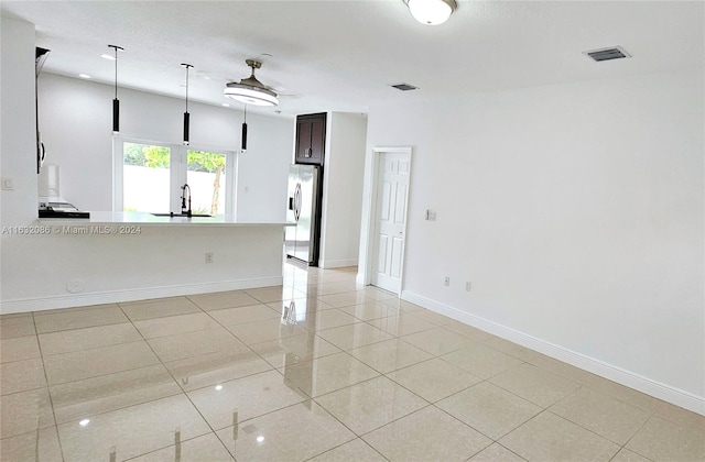 unfurnished room featuring ceiling fan, sink, and light tile patterned flooring