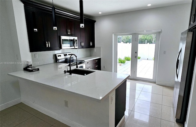 kitchen featuring stainless steel appliances, light stone counters, kitchen peninsula, light tile patterned floors, and french doors