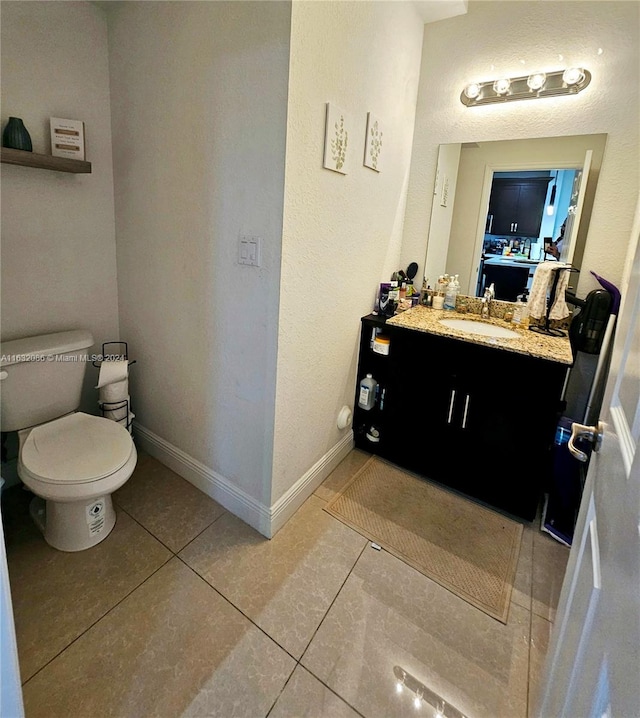 bathroom featuring vanity, tile patterned floors, and toilet