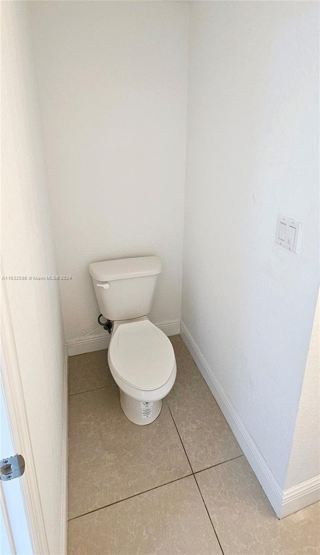 bathroom with toilet and tile patterned floors