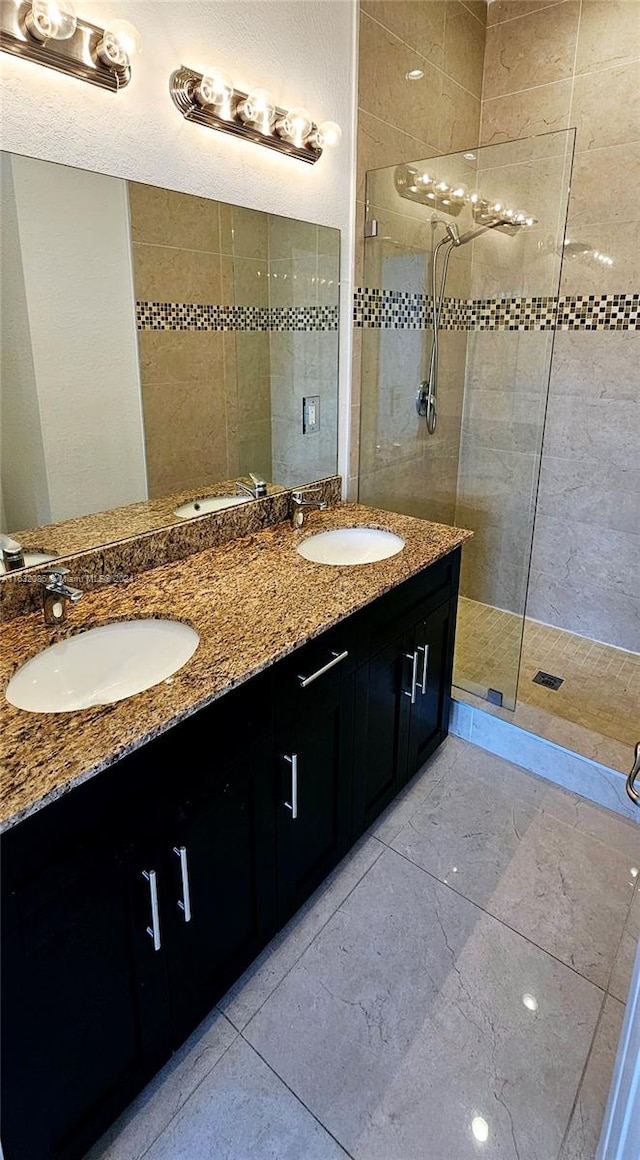 bathroom with tiled shower and vanity