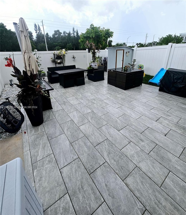 view of patio with a jacuzzi and a storage unit