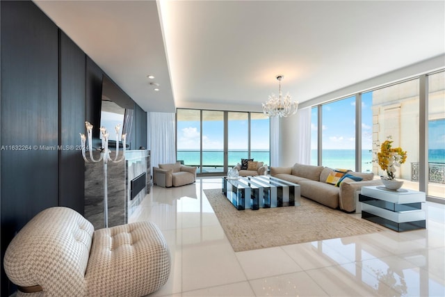 living room featuring light tile patterned flooring, floor to ceiling windows, a chandelier, and a high end fireplace