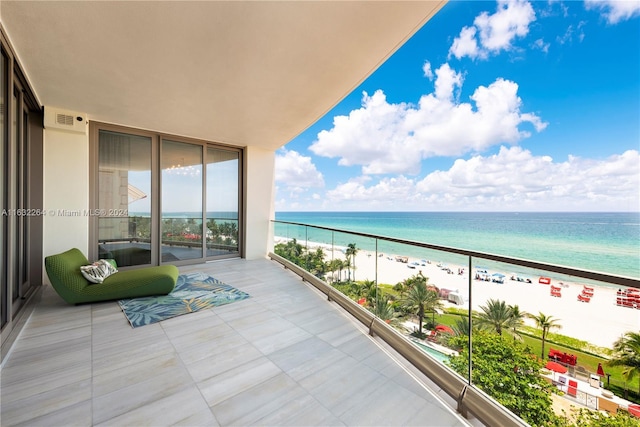 balcony featuring a view of the beach and a water view