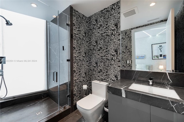 bathroom featuring tile walls, vanity, toilet, and an enclosed shower