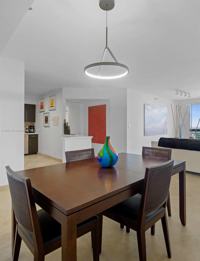 dining room with track lighting and light tile patterned floors