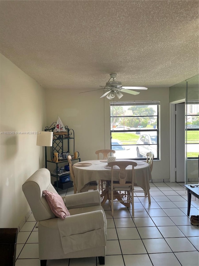 tiled dining area featuring a textured ceiling and ceiling fan