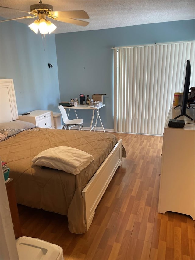 bedroom with ceiling fan, a textured ceiling, and light hardwood / wood-style flooring