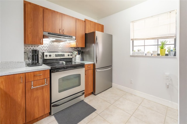 kitchen with decorative backsplash, appliances with stainless steel finishes, and light tile patterned floors