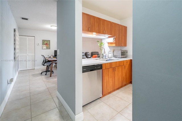 kitchen featuring sink, dishwasher, and light tile patterned floors