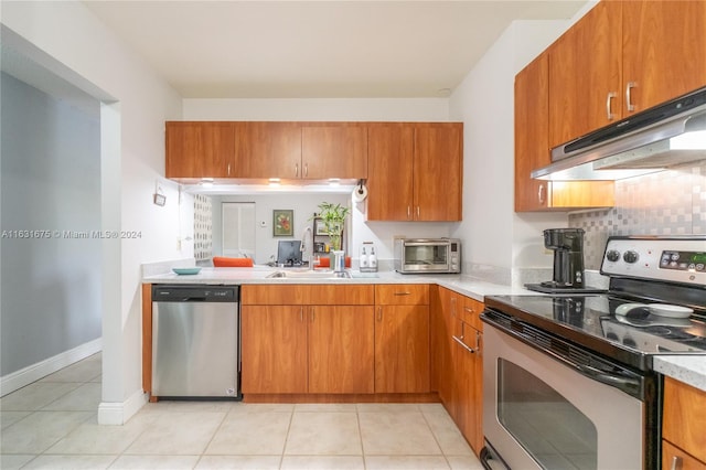 kitchen featuring light tile patterned floors, backsplash, sink, and stainless steel appliances