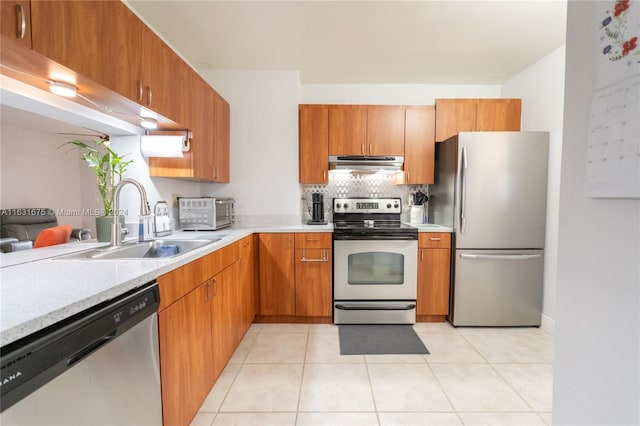 kitchen with appliances with stainless steel finishes, decorative backsplash, light tile patterned floors, and sink