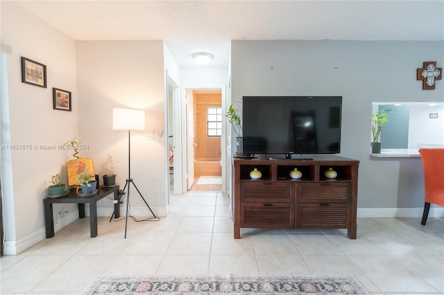 living room with a textured ceiling and light tile patterned floors