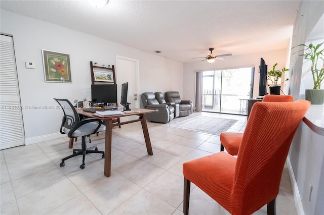 tiled office space with ceiling fan and a textured ceiling