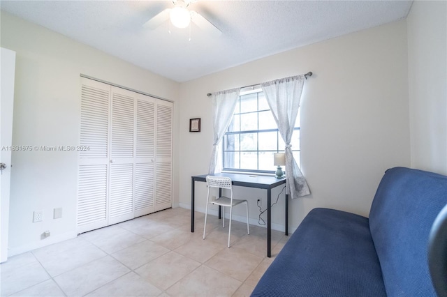 tiled home office featuring ceiling fan