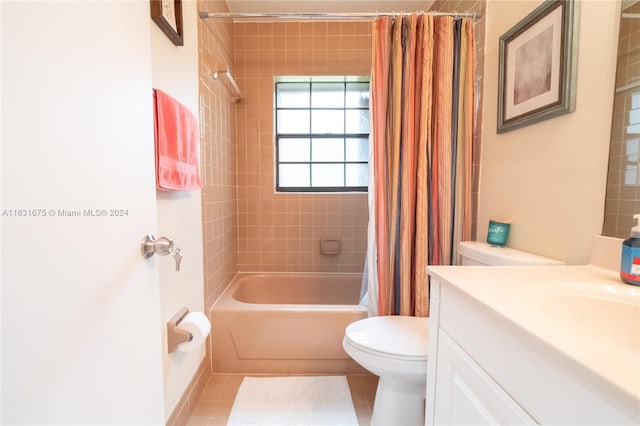 full bathroom featuring tile patterned flooring, toilet, vanity, and shower / bath combo with shower curtain