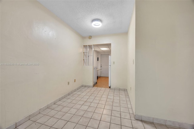 empty room featuring light tile patterned flooring and a textured ceiling