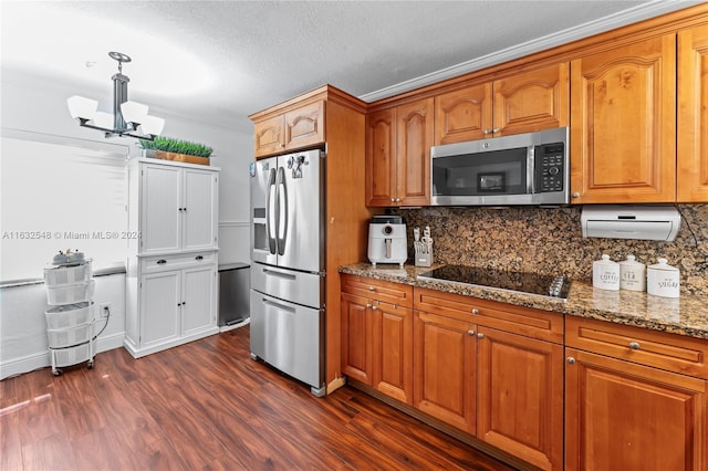 kitchen with tasteful backsplash, a chandelier, stainless steel appliances, light stone countertops, and dark wood-type flooring