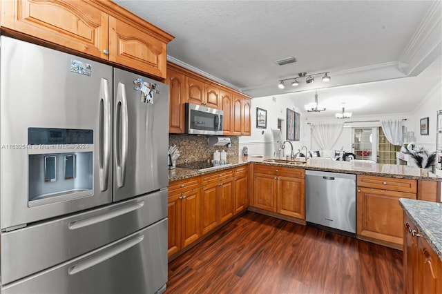 kitchen with appliances with stainless steel finishes, sink, decorative light fixtures, crown molding, and dark wood-type flooring