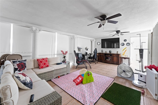 living room featuring decorative columns, a textured ceiling, and ceiling fan