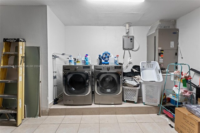 laundry room with washing machine and clothes dryer and light tile patterned floors