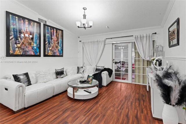 living room with wood-type flooring, crown molding, and a chandelier