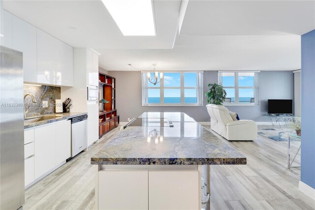 kitchen featuring sink, light hardwood / wood-style flooring, white cabinets, and appliances with stainless steel finishes